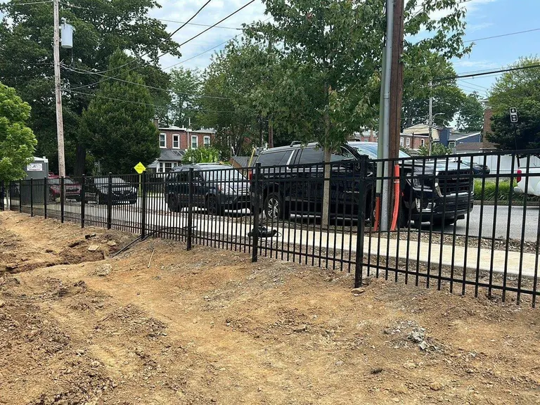 Black aluminum fence installed along a sidewalk frontage in Media, PA, with the yard behind it freshly graded