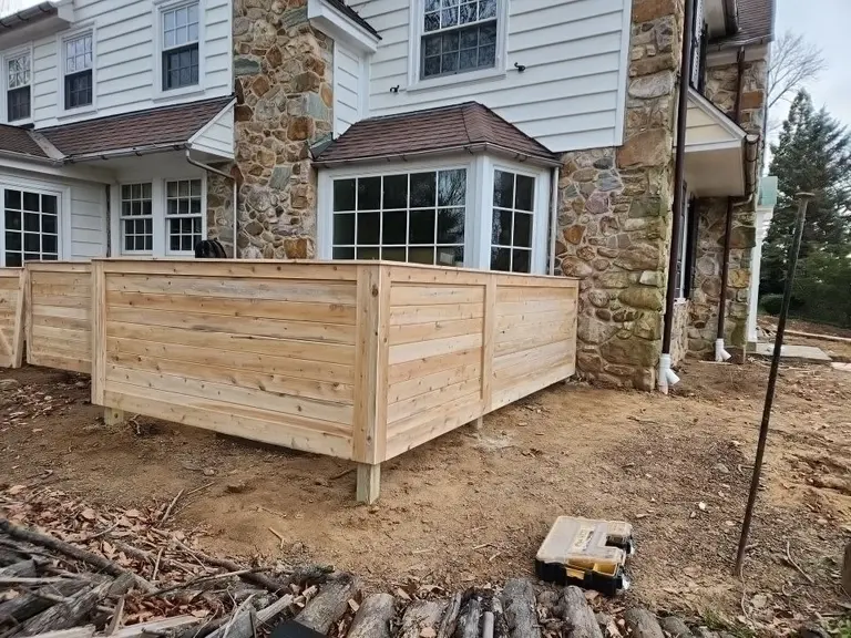 Horizontal cedar board privacy screen built around the corner of a stone and siding home in West Chester, PA