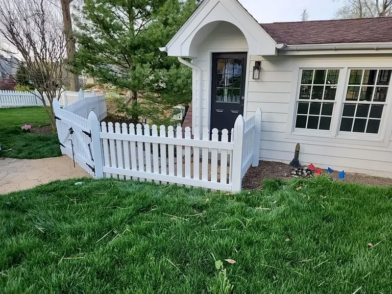 White vinyl picket fence and gate enclosing the side entry of a cottage-style home in West Chester, PA
